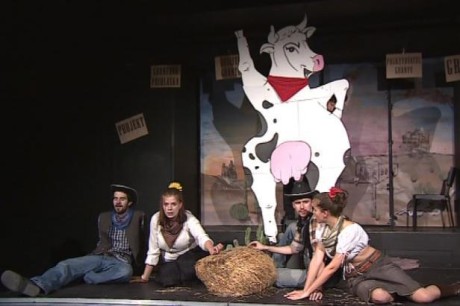Čtvercovému pódiu vévodí kulisa velké stylizované krávy s vemenem v laškovném postoji panáčkujícího psa. FOTO archiv ČT